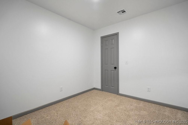 carpeted empty room featuring visible vents and baseboards