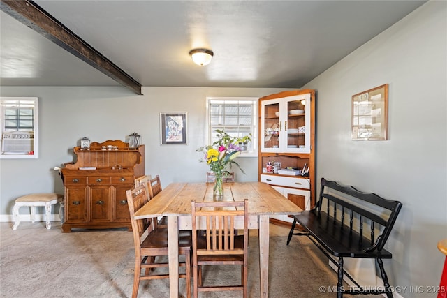 dining room featuring beamed ceiling, cooling unit, and light colored carpet