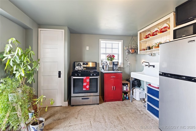 kitchen with open shelves, appliances with stainless steel finishes, and carpet