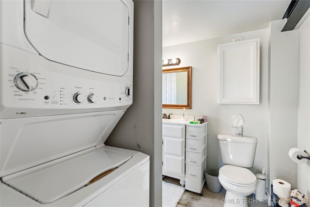 clothes washing area with laundry area, stacked washer and dryer, and a sink