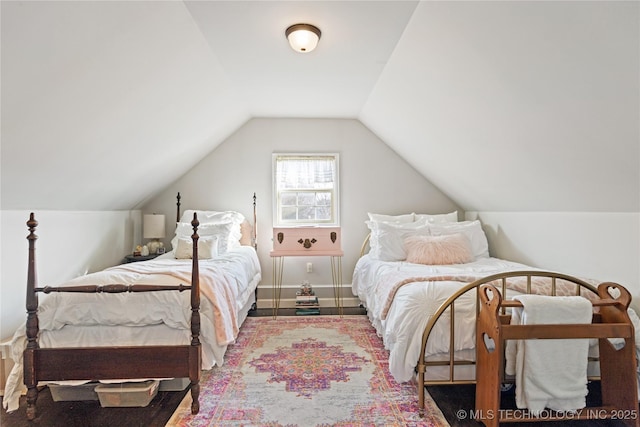 bedroom with lofted ceiling and baseboards