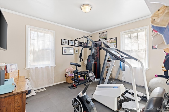exercise room featuring baseboards, ornamental molding, and plenty of natural light