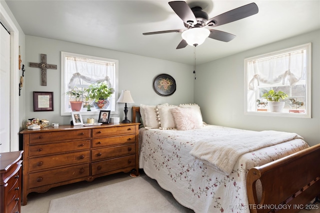 bedroom featuring light carpet and ceiling fan