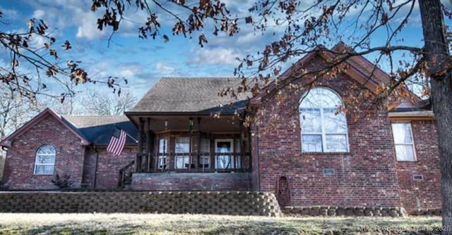 exterior space featuring brick siding and a porch