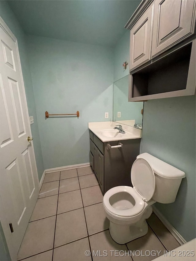 bathroom with tile patterned flooring, toilet, vanity, and baseboards