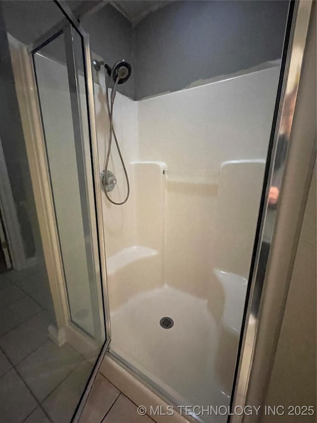 full bath with tile patterned floors and a shower stall