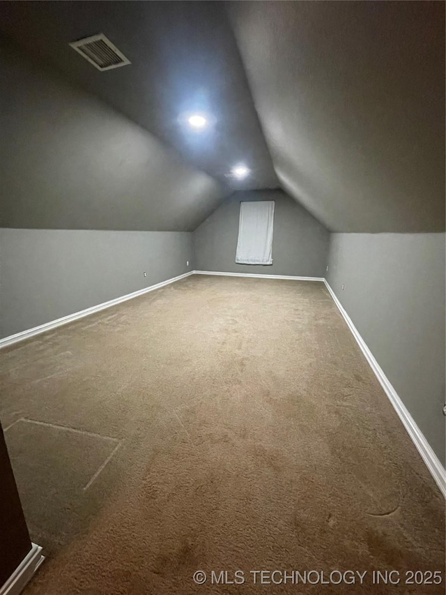 additional living space with lofted ceiling, carpet flooring, baseboards, and visible vents