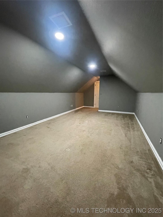 bonus room with vaulted ceiling, visible vents, baseboards, and carpet floors