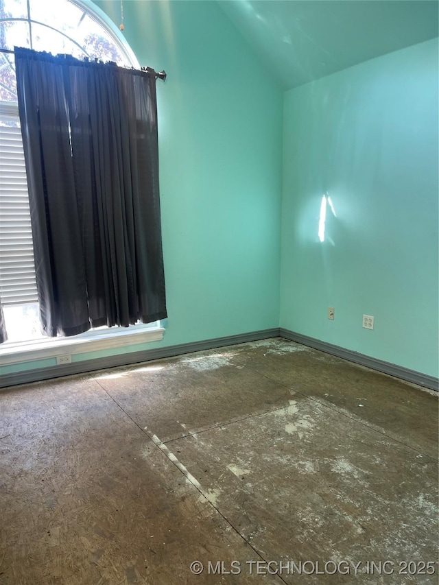 unfurnished room featuring vaulted ceiling