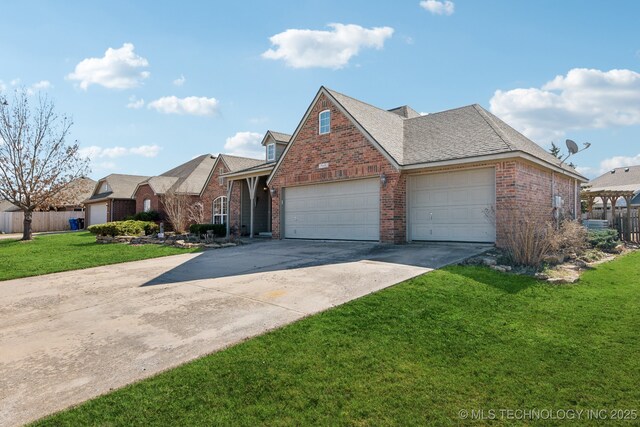 traditional-style home featuring brick siding, a garage, a front lawn, and fence