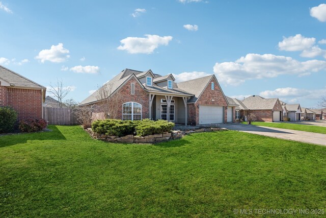 traditional-style home with brick siding, fence, concrete driveway, a front yard, and a garage