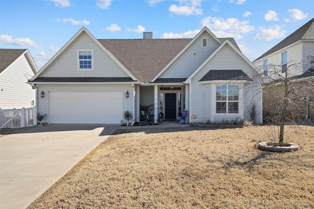 view of front of house featuring a chimney, concrete driveway, roof with shingles, and fence