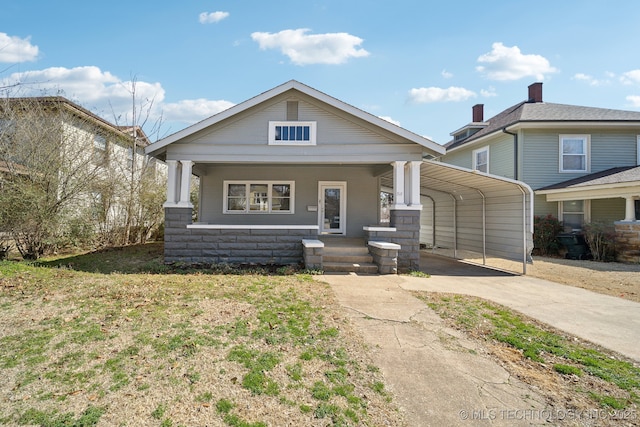 view of front facade featuring a detached carport, concrete driveway, and covered porch