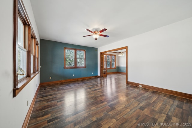 spare room with ceiling fan, baseboards, and wood finished floors