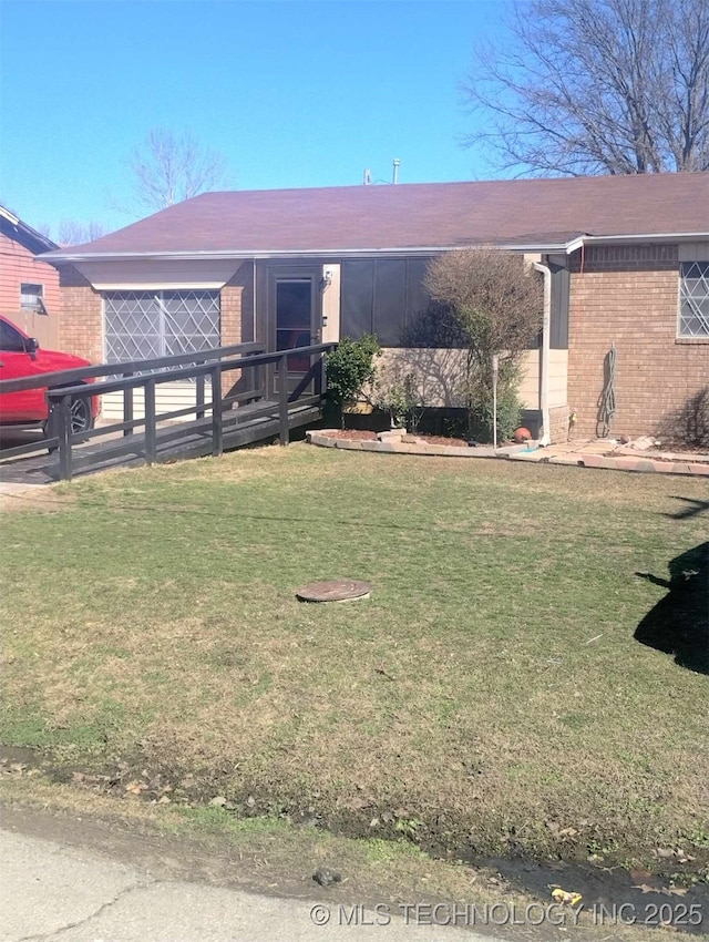 single story home with a front lawn and brick siding