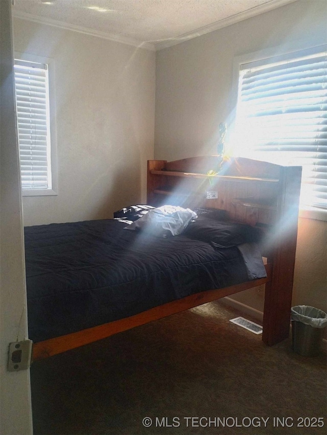 carpeted bedroom with visible vents and ornamental molding