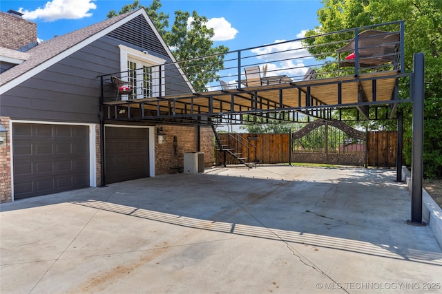 exterior space featuring stairway, brick siding, and driveway