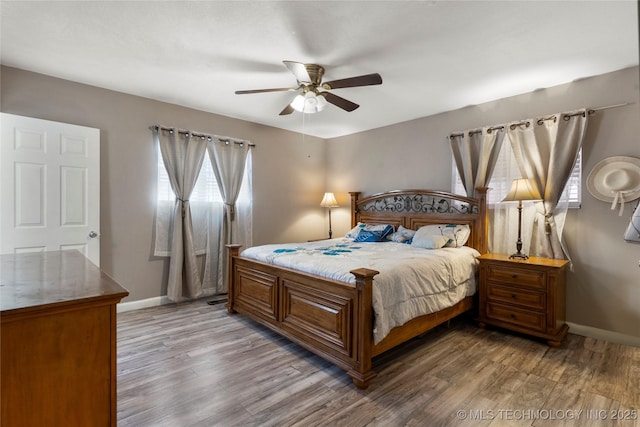 bedroom featuring a ceiling fan, wood finished floors, and baseboards