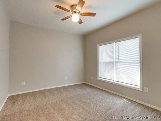 empty room featuring baseboards, carpet, and a ceiling fan