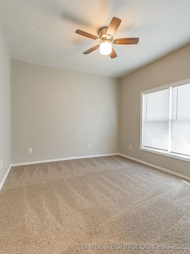 spare room with carpet flooring, baseboards, and a ceiling fan