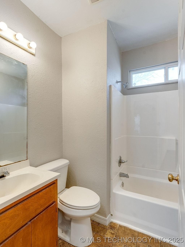 bathroom with toilet, a textured wall, tile patterned floors, vanity, and  shower combination