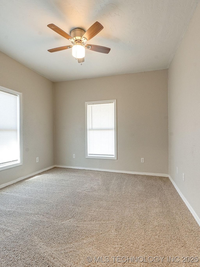 empty room featuring baseboards, ceiling fan, and carpet flooring