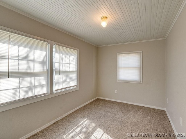 carpeted empty room with baseboards and crown molding