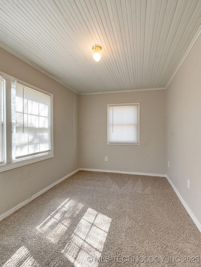 unfurnished room with crown molding, carpet flooring, and baseboards