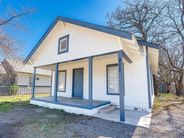 view of front of home featuring covered porch and fence