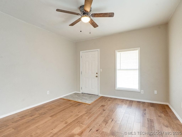 spare room with a ceiling fan, baseboards, and light wood-type flooring