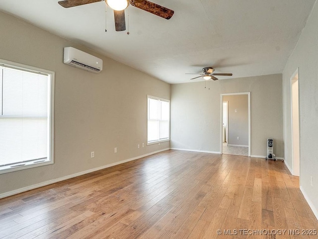 unfurnished room featuring a ceiling fan, an AC wall unit, light wood-style floors, and baseboards