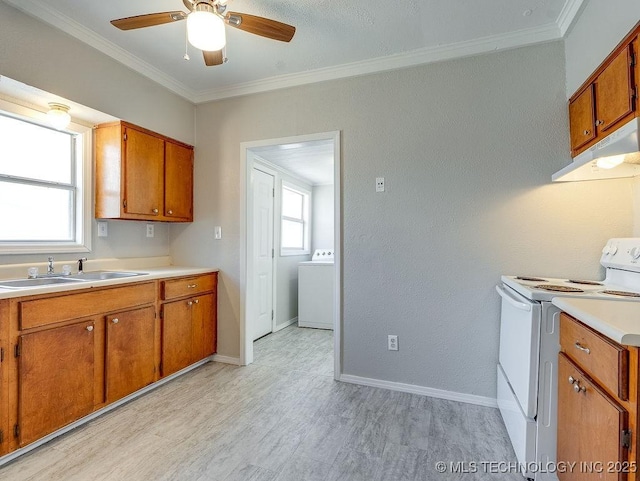 kitchen featuring brown cabinetry, washer / clothes dryer, a sink, under cabinet range hood, and white electric range