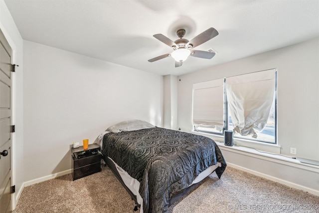 carpeted bedroom with ceiling fan and baseboards