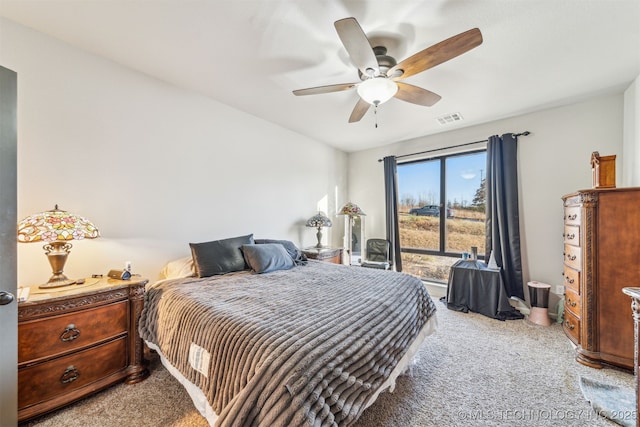 bedroom with light carpet, visible vents, and a ceiling fan