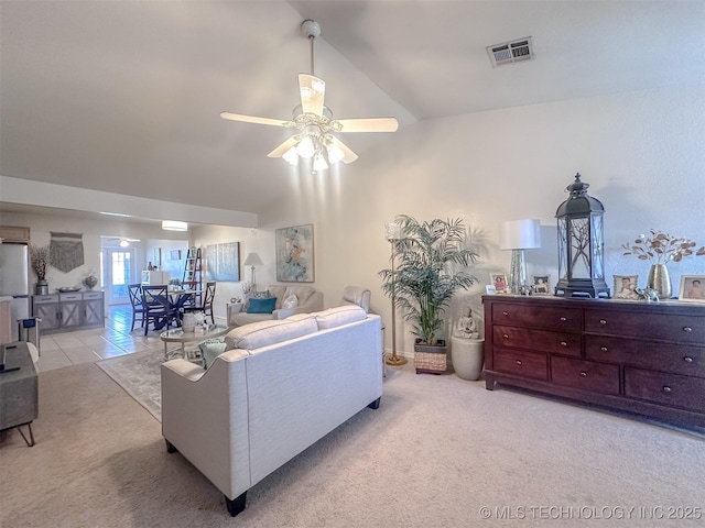 carpeted living area featuring tile patterned flooring, lofted ceiling, visible vents, and ceiling fan