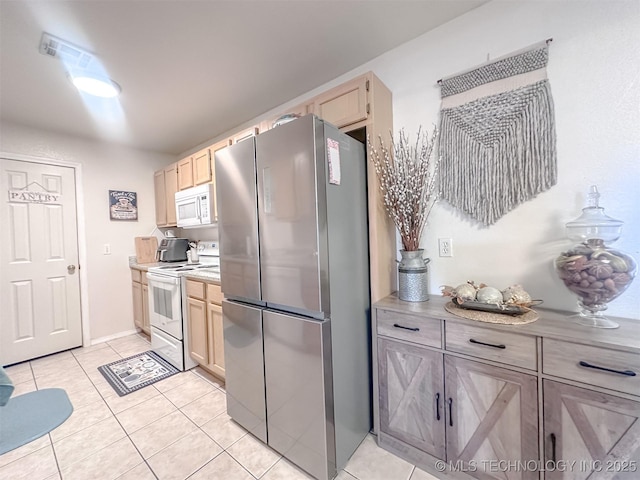 kitchen featuring white appliances, light tile patterned flooring, light brown cabinetry, and light countertops