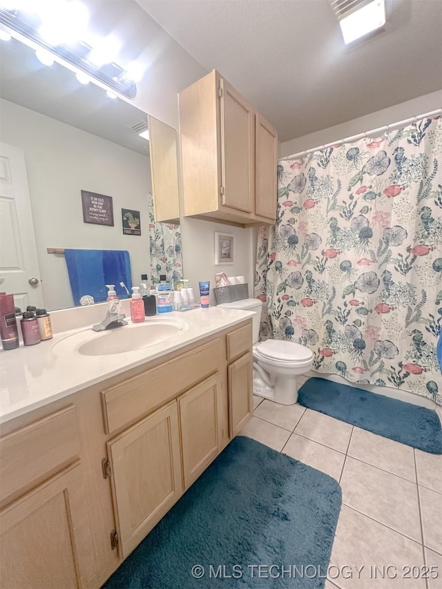 bathroom with curtained shower, toilet, vanity, and tile patterned flooring