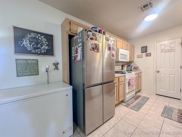 kitchen featuring visible vents, light brown cabinetry, light countertops, light tile patterned floors, and white appliances