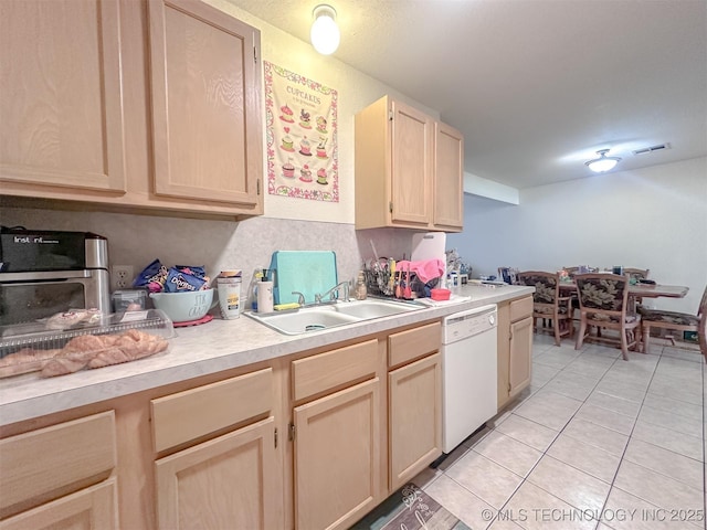 kitchen with light brown cabinetry, a sink, light tile patterned flooring, light countertops, and dishwasher