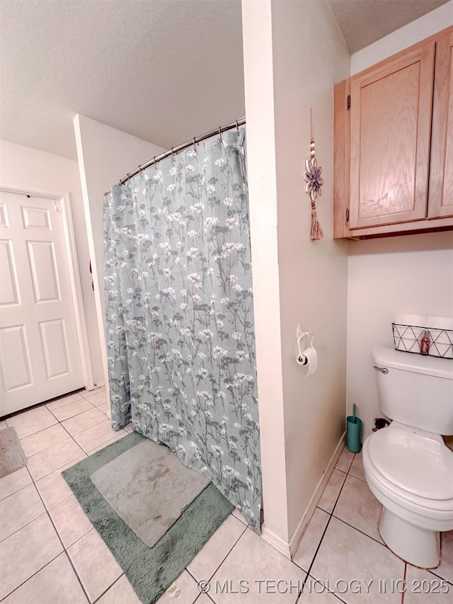 full bathroom with tile patterned floors, a shower with curtain, baseboards, and toilet