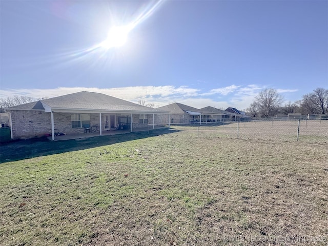 rear view of property with a fenced backyard, a patio, and a yard