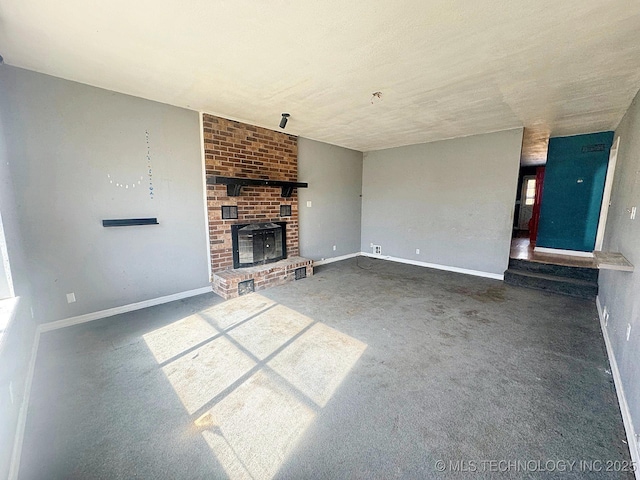 unfurnished living room featuring baseboards, a brick fireplace, and carpet flooring