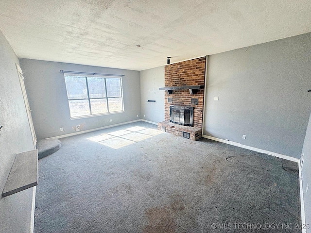 unfurnished living room with carpet flooring, a fireplace, a textured ceiling, and baseboards