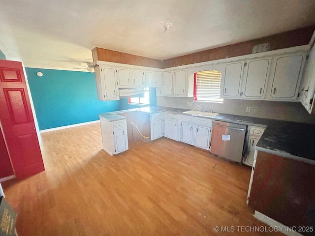 kitchen with a sink, light wood-style flooring, white cabinetry, and stainless steel dishwasher