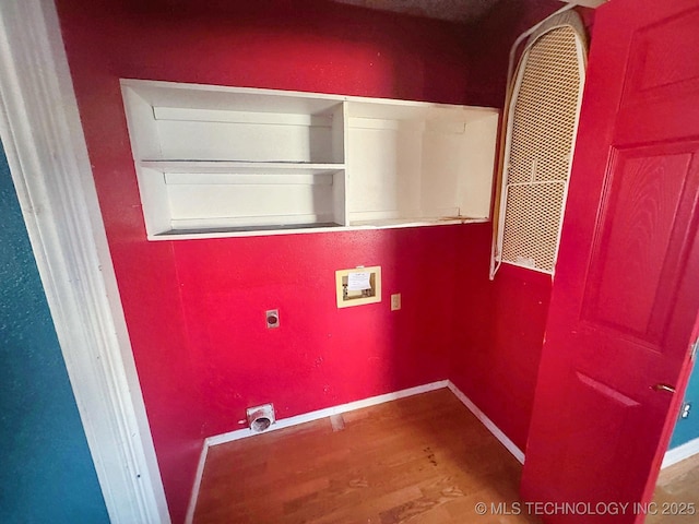 clothes washing area featuring baseboards, washer hookup, wood finished floors, and laundry area