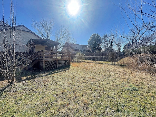 view of yard featuring a deck, stairs, and fence