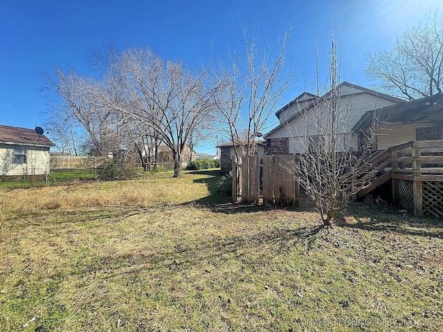 view of yard featuring a wooden deck and fence