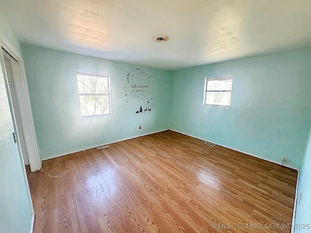 empty room featuring visible vents and wood finished floors