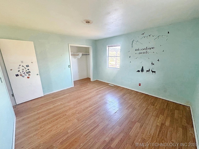 unfurnished bedroom with a closet and wood finished floors