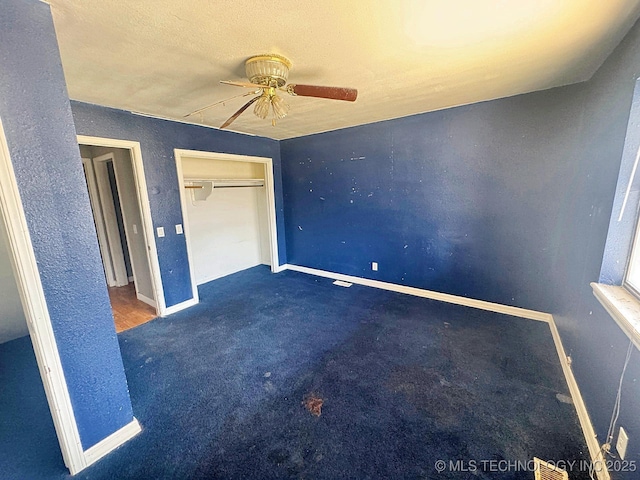 unfurnished bedroom with a closet, baseboards, carpet floors, and ceiling fan